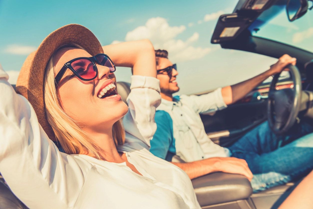 A woman and man sitting in the back of a car.